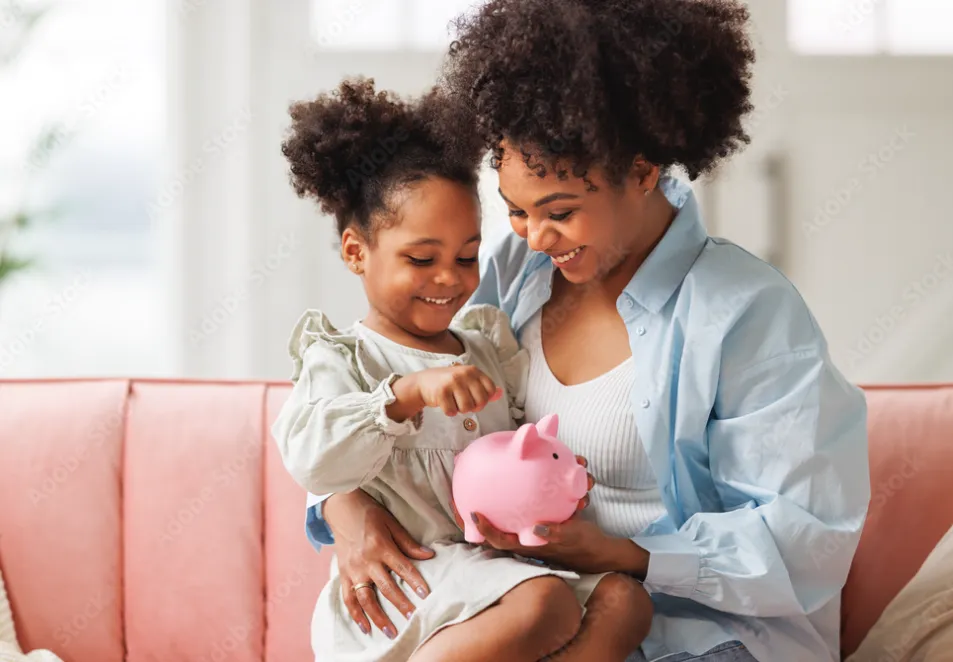 A mother and daughter putting coins in a piggy bank